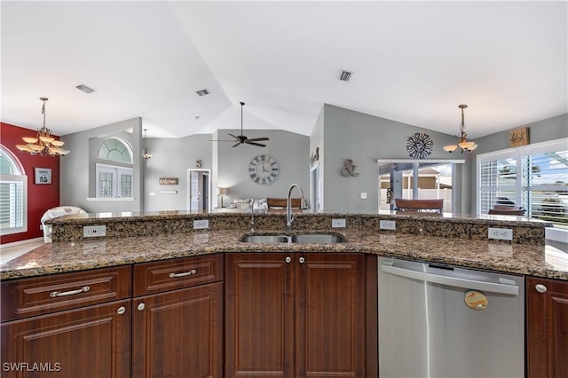 kitchen with lofted ceiling, sink, dark stone countertops, stainless steel dishwasher, and pendant lighting