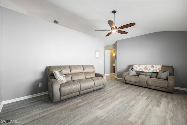 living room featuring ceiling fan, lofted ceiling, and light wood-type flooring