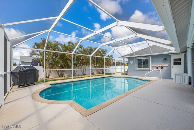 view of pool featuring grilling area, a patio, and glass enclosure