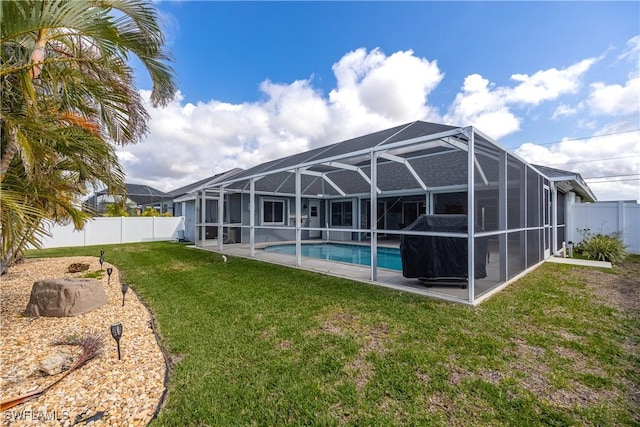 view of pool featuring glass enclosure and a lawn