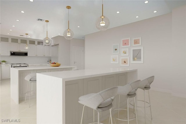 342 Germain Ave, Naples, FL 34108 - kitchen featuring recessed lighting, a large island, light tile patterned flooring, and stainless steel microwave