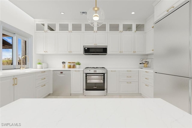 342 Germain Ave, Naples, FL 34108 - kitchen with appliances with stainless steel finishes, white cabinets, a sink, visible vents, and pendant lighting