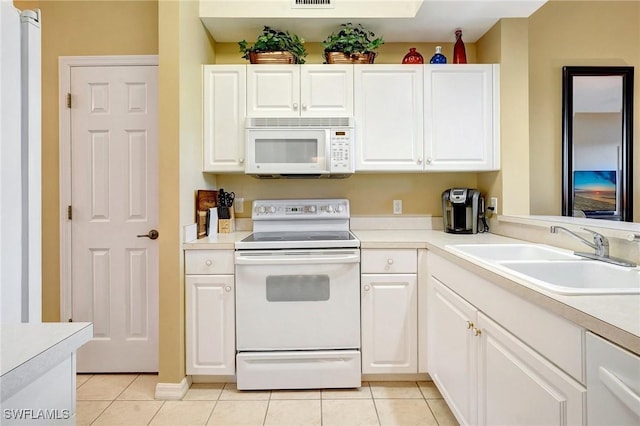 kitchen featuring sink, white appliances, light tile patterned floors, and white cabinets