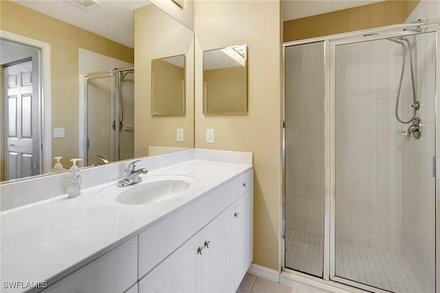 bathroom featuring vanity, tile patterned flooring, and walk in shower