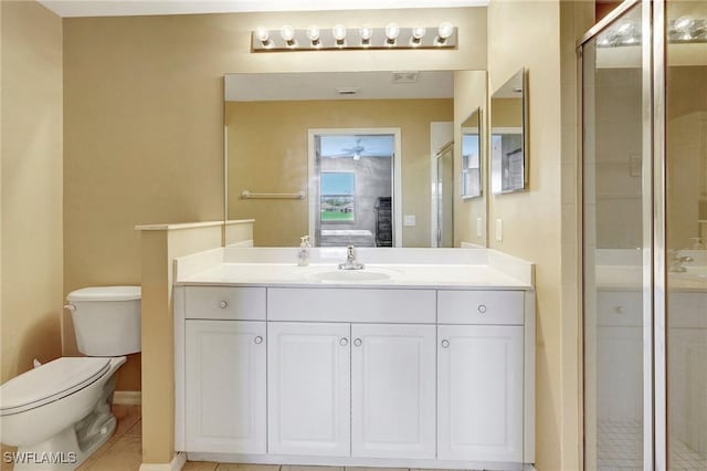 bathroom featuring ceiling fan, tile patterned flooring, an enclosed shower, vanity, and toilet