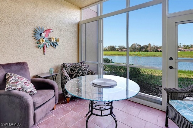 sunroom / solarium featuring a water view