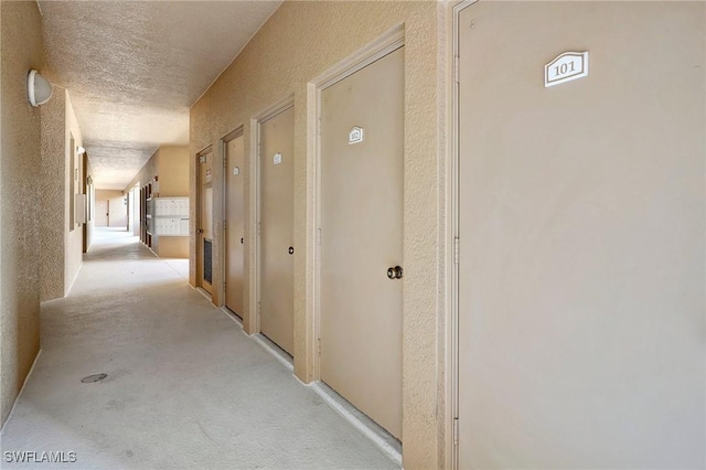 hall with a textured ceiling