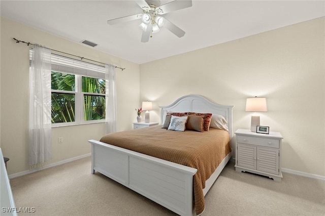 bedroom featuring baseboards, visible vents, and light colored carpet