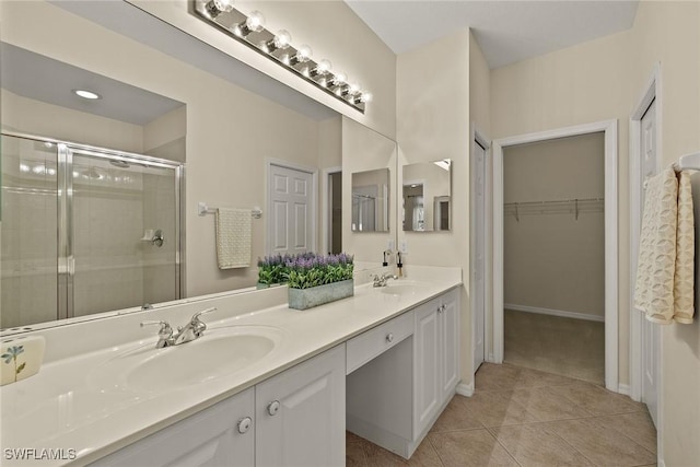 full bath with tile patterned flooring, a sink, a spacious closet, double vanity, and a stall shower