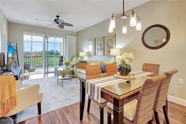 dining room featuring ceiling fan, wood finished floors, and baseboards