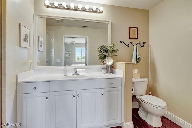 bathroom with vanity, wood-type flooring, walk in shower, and toilet