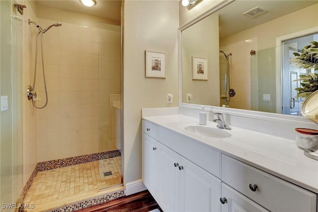 bathroom featuring visible vents, a shower stall, and vanity