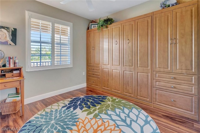 bedroom with light wood-type flooring, baseboards, and a ceiling fan