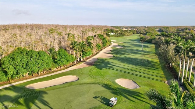 birds eye view of property featuring view of golf course and a wooded view