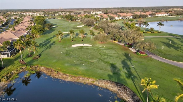 drone / aerial view with a residential view, a water view, and golf course view