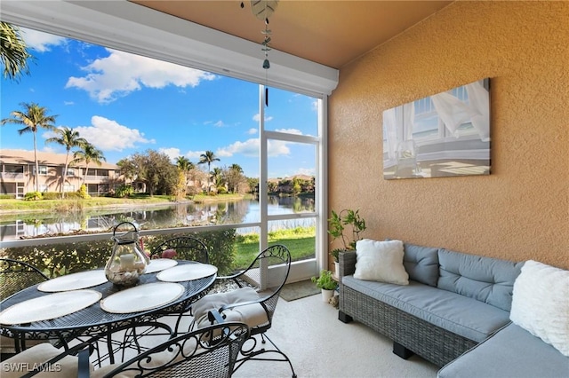 sunroom featuring vaulted ceiling, a water view, and plenty of natural light