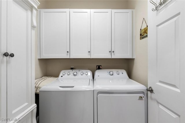 laundry room featuring cabinets and washer and clothes dryer