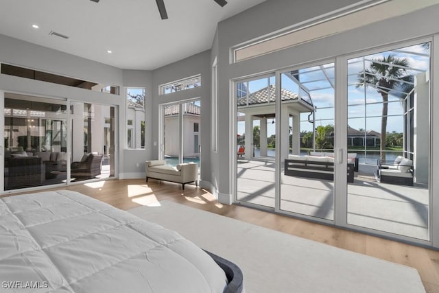 4306 Sanctuary Way, Bonita Springs, FL 34134 - bedroom with access to exterior, visible vents, a towering ceiling, wood finished floors, and baseboards