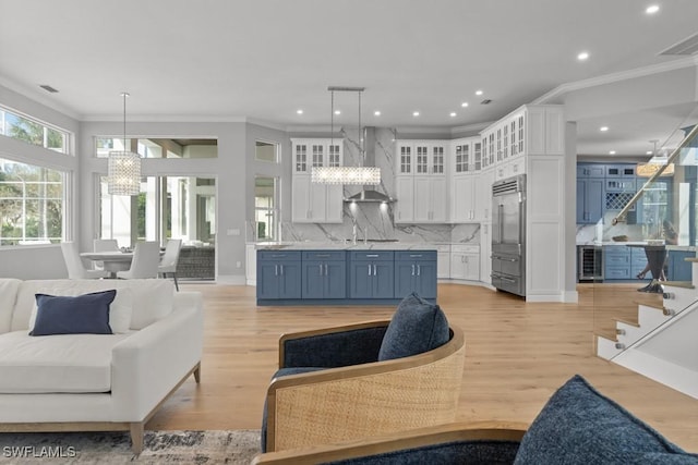 4306 Sanctuary Way, Bonita Springs, FL 34134 - kitchen with wine cooler, a notable chandelier, blue cabinetry, open floor plan, and white cabinetry