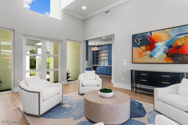 4306 Sanctuary Way, Bonita Springs, FL 34134 - living area featuring a high ceiling, visible vents, baseboards, ornamental molding, and light wood-type flooring