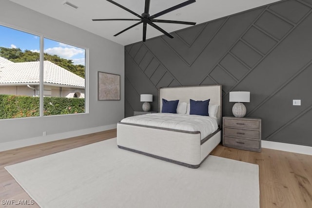 4306 Sanctuary Way, Bonita Springs, FL 34134 - bedroom featuring visible vents, an accent wall, ceiling fan, wood finished floors, and baseboards