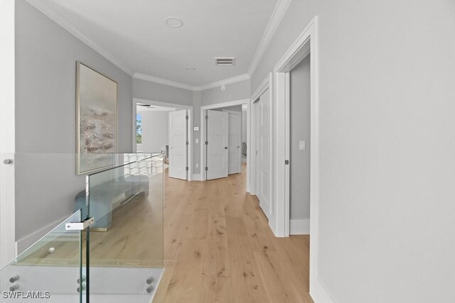 4306 Sanctuary Way, Bonita Springs, FL 34134 - hallway with light wood-style flooring, an upstairs landing, baseboards, visible vents, and crown molding