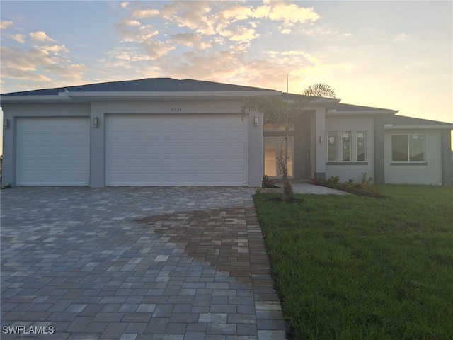 view of front of house with a garage and a lawn