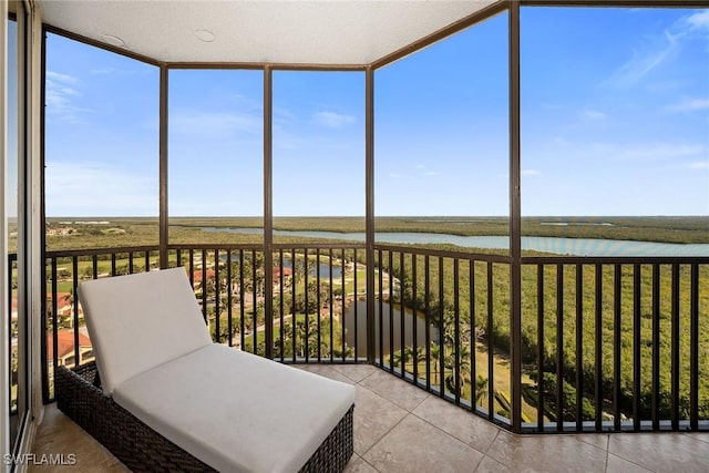 sunroom / solarium featuring a water view