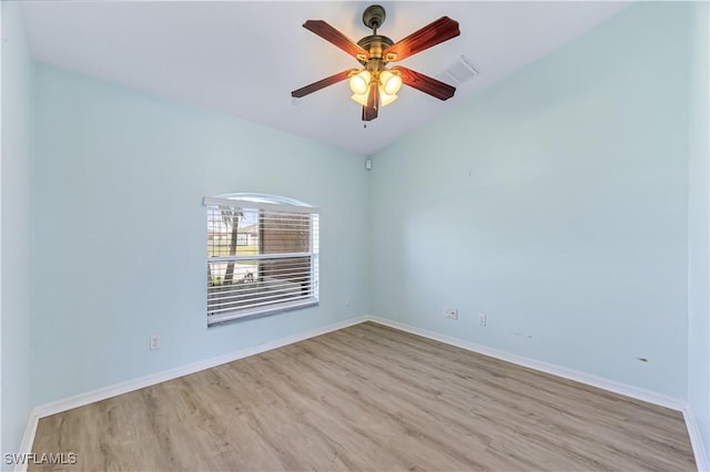 spare room with ceiling fan, vaulted ceiling, and light wood-type flooring