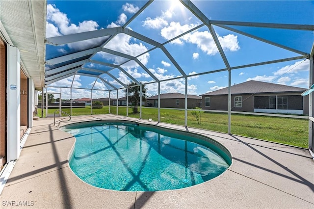 view of swimming pool with a yard, a patio area, and glass enclosure