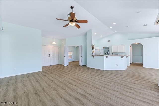 unfurnished living room with ceiling fan, high vaulted ceiling, and light hardwood / wood-style floors