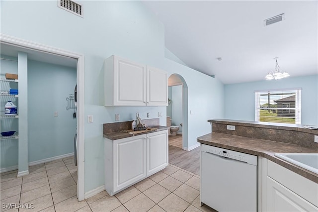 kitchen with white dishwasher, light tile patterned floors, and white cabinetry