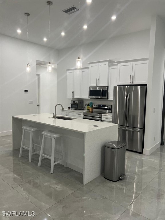 kitchen with sink, a center island with sink, white cabinets, and appliances with stainless steel finishes