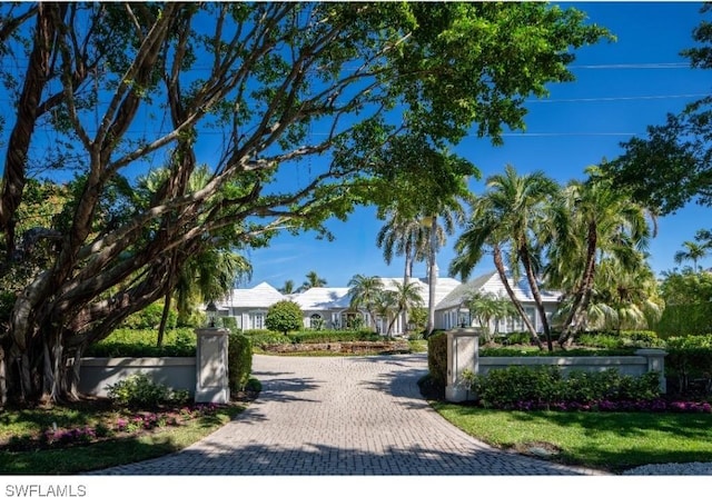 view of community with fence and decorative driveway