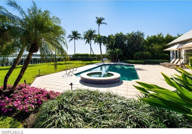 view of swimming pool featuring a patio area, a pool with connected hot tub, and a lawn