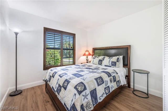 bedroom featuring baseboards and wood finished floors