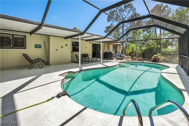 outdoor pool featuring glass enclosure and a patio area