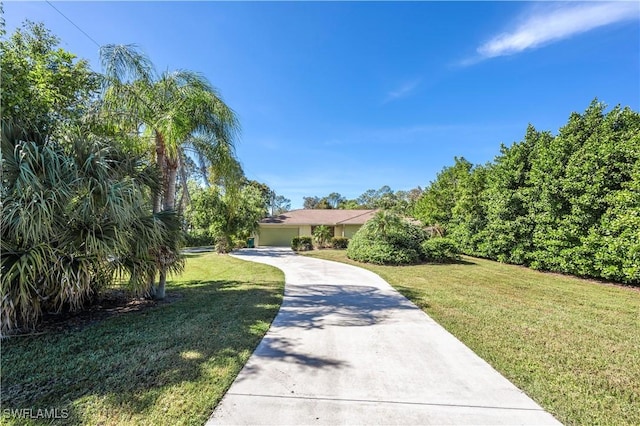 obstructed view of property featuring driveway and a front yard