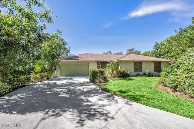 single story home featuring a garage, driveway, a front lawn, and stucco siding