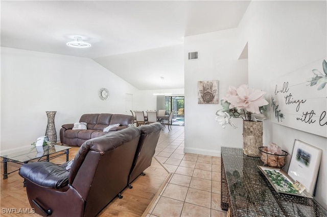 living area featuring lofted ceiling, visible vents, baseboards, and light tile patterned floors