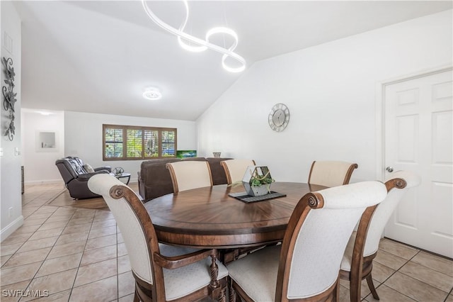 dining space with light tile patterned floors, vaulted ceiling, and an inviting chandelier