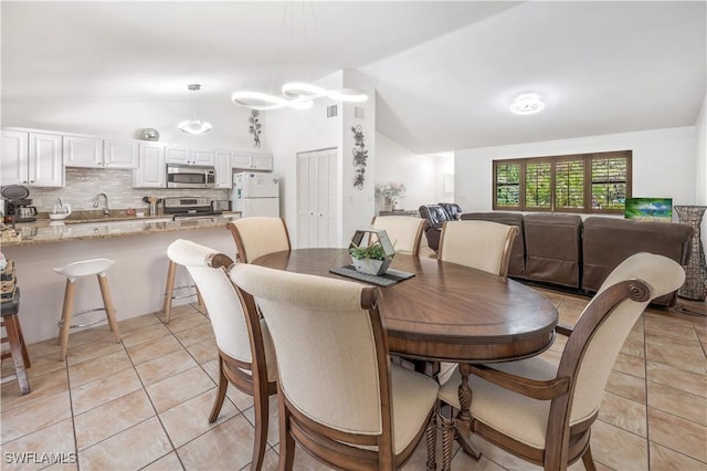 dining room with vaulted ceiling and light tile patterned floors