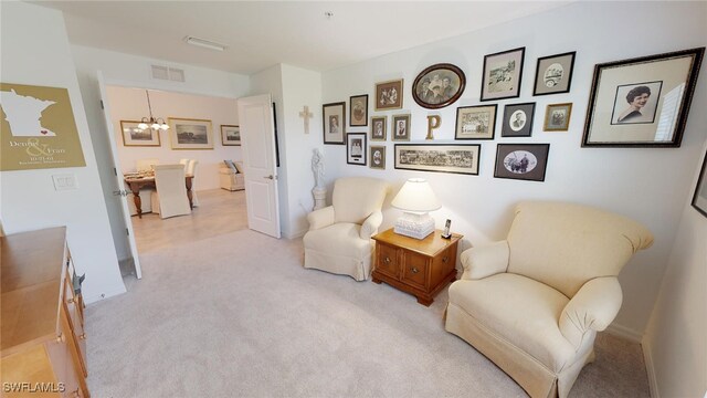 6082 National Blvd Unit 128, Ave Maria, FL 34142 - living area featuring light carpet and an inviting chandelier