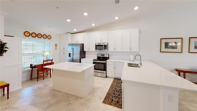 6082 National Blvd Unit 128, Ave Maria, FL 34142 - kitchen with vaulted ceiling, appliances with stainless steel finishes, sink, white cabinets, and a center island