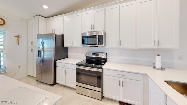 6082 National Blvd Unit 128, Ave Maria, FL 34142 - kitchen with light tile patterned floors, sink, white cabinets, and appliances with stainless steel finishes