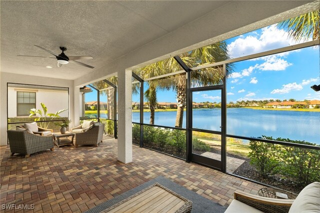 sunroom with a water view and ceiling fan