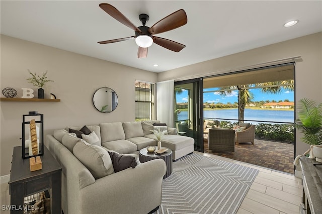 living room with a water view and ceiling fan