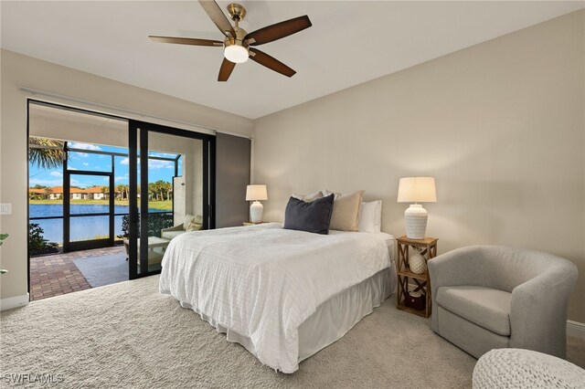 carpeted bedroom with a water view, access to outside, and ceiling fan