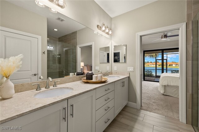 bathroom with vanity, walk in shower, ceiling fan, and a water view