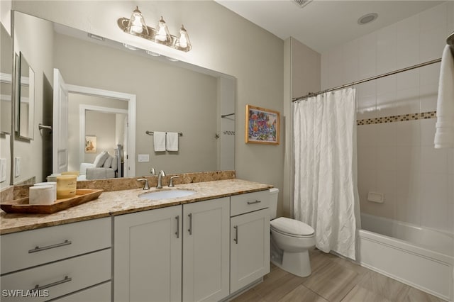 full bathroom with vanity, shower / bath combo, and toilet